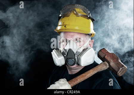 Un sauveteur porte un masque respiratoire dans une atmosphère de fumée toxique, transportant une masse. Banque D'Images