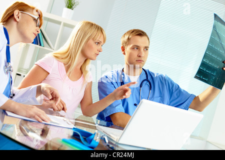 Portrait de deux médecins et d'young woman reading x-ray à l'hôpital Banque D'Images
