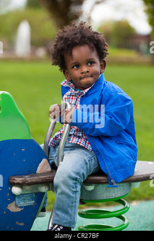 Outdoor portrait of a cute baby boy noir jouer au jeu pour enfants Banque D'Images