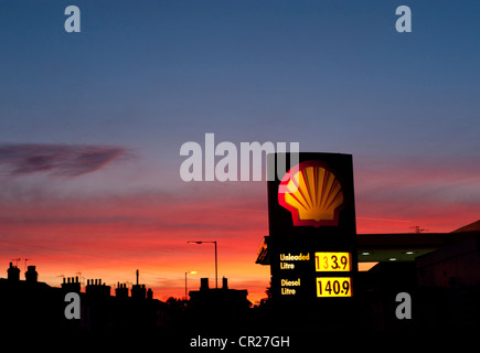 Garage Shell signe contre un ciel rouge le soir, Stratford-upon-Avon, Warwickshire, England, UK Banque D'Images