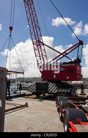 Yacht à moteur (l'aube, Affaire) d'être déchargé du camion dans le port de plaisance de Torquay, Devon, UK. Banque D'Images