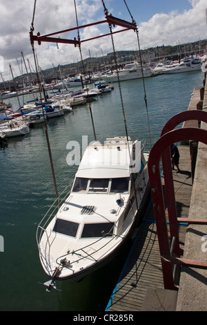 Yacht à moteur (l'aube, Affaire) d'être déchargé du camion dans le port de plaisance de Torquay, Devon, UK. Banque D'Images