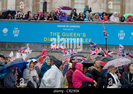 Jubilé de diamant de la Reine 2012 – les fêtards de Trafalgar Square se mettent à l’abri de la pluie alors que les célébrations se poursuivent malgré le mauvais temps. Banque D'Images