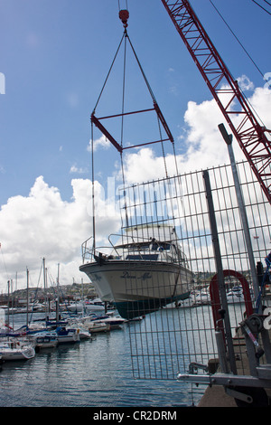 Yacht à moteur (l'aube, Affaire) d'être déchargé du camion dans le milieu marin à Torquay, Devon, UK. Banque D'Images