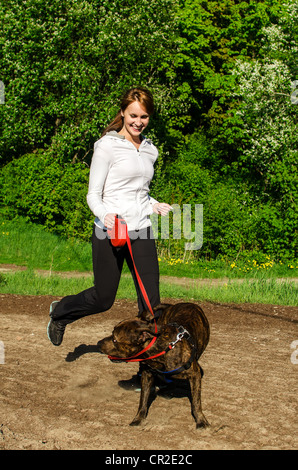 Marcher avec une femme American Stafford dans le parc Banque D'Images