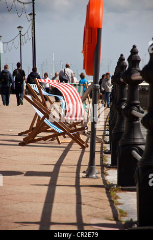 Des chaises vides sur le front de mer de Torquay qui souffle dans la brise vent. Banque D'Images