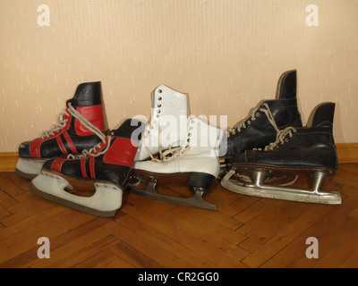 Trois paires de vieux patins allongé sur le parquet Banque D'Images