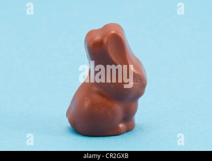 Lapin de Pâques en chocolat symbole sur fond bleu. Banque D'Images