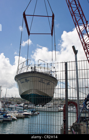 Yacht à moteur (l'aube, Affaire) d'être déchargé du camion dans le milieu marin à Torquay, Devon, UK. Banque D'Images