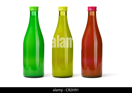 Trois bouteilles en verre de jus de fruits sur fond blanc Banque D'Images