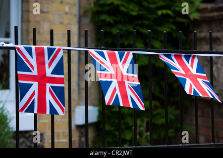 Union Jack noir et les drapeaux sur la clôture de jardin, UK. Banque D'Images