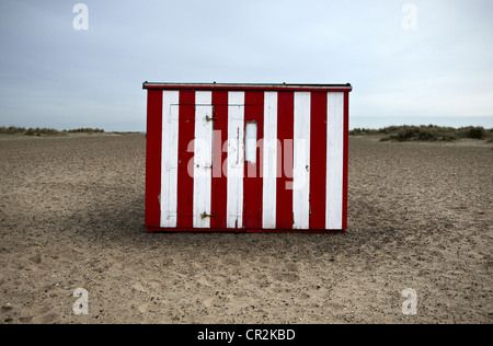 Le rouge et blanc à rayures Beach Hut situé sur une plage. Banque D'Images