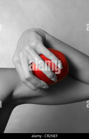 La jeune fille tient dans la main une pomme rouge. Décoloration partielle Banque D'Images