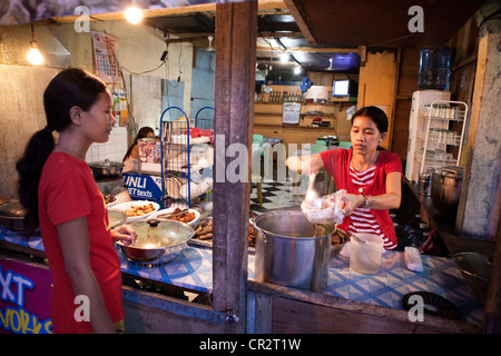 Philippine à l'achat d'aliments dans un éventaire routier eatery. Lapu-Lapu City, Metro Cebu, Mactan Island, Visayas, Philippines. Banque D'Images