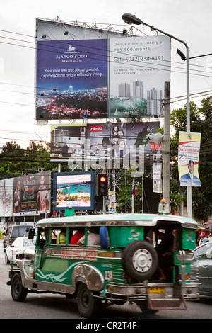 Conduite Jeepney passé les panneaux publicitaires. La ville de Cebu, Cebu, Visayas, Philippines. Banque D'Images