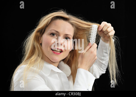 Jeune femme brosser ses cheveux Banque D'Images