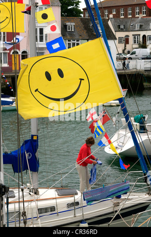 Un brillant noir sur jaune Smiley drapeau sur un voilier Banque D'Images
