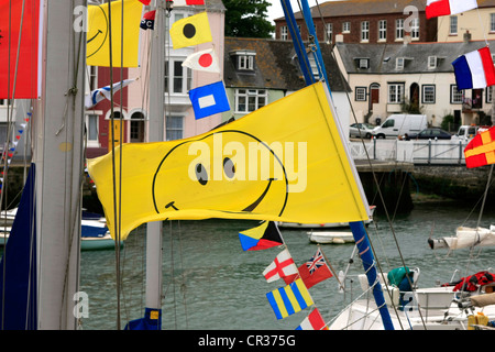 Un brillant noir sur jaune Smiley drapeau sur un voilier Banque D'Images