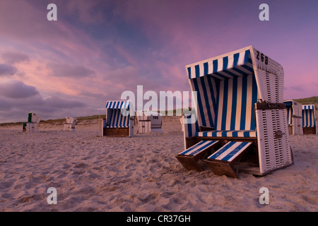 Chaises de plage en osier couvert sur la plage juste après le coucher du soleil, l'île de Sylt, Hoernum, Schleswig-Holstein, district de Frise du Nord Banque D'Images