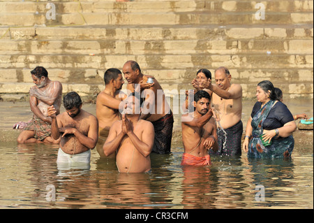 Les croyants sur les ghats ou étapes sur les bords du Gange River dans les ablutions rituelles, Benares, Varanasi, Uttar Pradesh, Inde Banque D'Images