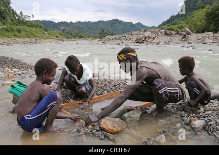 Le panoramique de la famille d'or dans la rivière polluée Jaba découlant de la mine de cuivre de Panguna. La région autonome de Bougainville, PNG Banque D'Images