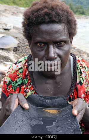 Or dans la batée femme Jaba polluée rivière qui coule à partir de la mine de cuivre de Panguna. La région autonome de Bougainville, PNG Banque D'Images