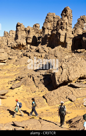 L'Algérie, Sahara près de Djanet, Tassili N'Ajjer, Massif du parc national classé au Patrimoine Mondial de l'UNESCO, les randonneurs et la formation de la roche volcanique Banque D'Images