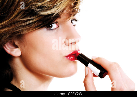Young woman applying lipstick Banque D'Images