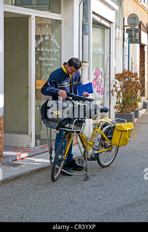 Avec La Poste facteur yellow bicycle avec postman livrer le courrier dans la Grand Rue Sainte Foy les Lyon France Banque D'Images