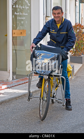 Avec La Poste facteur yellow bicycle avec postman livrer le courrier dans la Grand Rue Sainte Foy les Lyon France Banque D'Images