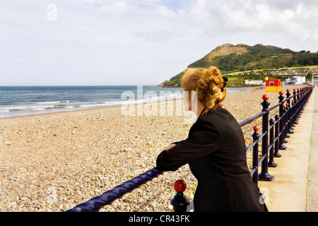 Femme aux cheveux rouges irlandais face à la mer. Cliché pris sur la promenade de Bray, Irlande. Banque D'Images