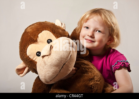 Fille, 5, avec un singe en peluche Banque D'Images