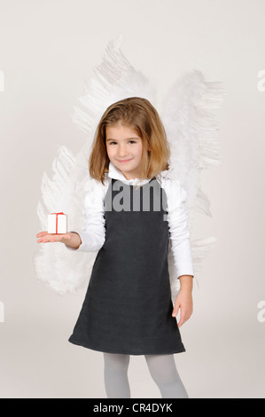 Fille avec angel wings with Christmas present Banque D'Images