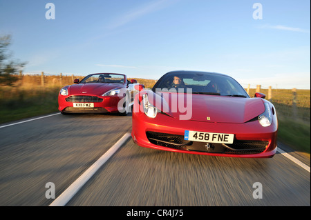 Ferrari 458 Italia et Aston Martin Virage route côte à côte au coucher du soleil Banque D'Images