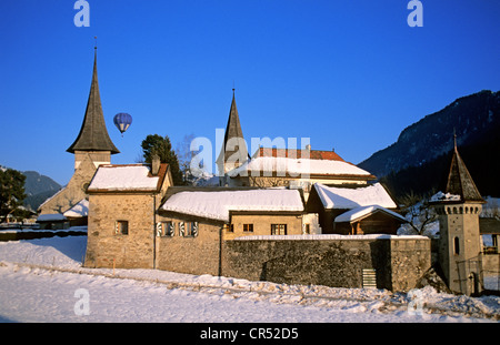 La Suisse, Canton de Vaud, Pays-d'Enhaut, Rougemont, l'église du prieuré du 11ème siècle en hiver et ballon à air chaud Banque D'Images