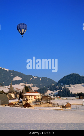 La Suisse, Canton de Vaud, Pays-d'Enhaut, Rougemont, l'église du prieuré du 11ème siècle en hiver et ballon à air chaud Banque D'Images