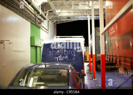 Voitures, camions et camionnettes sur le pont des véhicules d'un ferry moderne dans la nuit dans le port de Belfast Irlande du Nord uk Banque D'Images