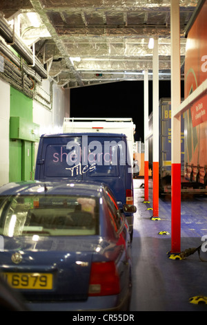 Voitures, camions et camionnettes sur le pont des véhicules d'un ferry moderne dans la nuit dans le port de Belfast Irlande du Nord uk Banque D'Images