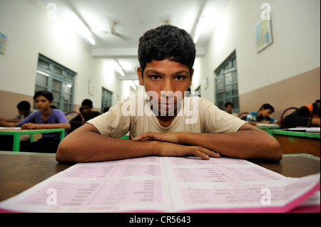 Se plonger dans un manuel d'étudiant de l'école, l'enseignement dans une école intermédiaire, Youhanabad, Lahore, Punjab, Pakistan, Asie Banque D'Images