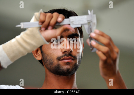 Formation professionnelle en tant qu'étudiant de métallurgistes, formation professionnelle contrôle de son travail avec un lingot d'acier de précision, d'Youhanabad, Lahore Banque D'Images