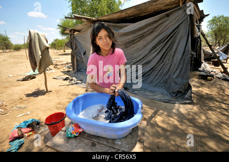 Jeune femme, 18 ans, de faire la lessive dans une cuve en plastique, communauté autochtone de Santa Maria, Gran Chaco, La province de Salta Banque D'Images