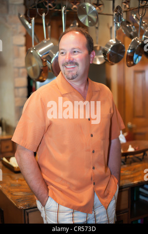 Middle-aged man smiling dans la cuisine de sa belle maison Banque D'Images