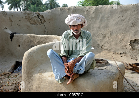 Un homme âgé portant un turban est assis sur un four à pain, Lehar Basti Walla village, Pubjab, Pakistan, Asie Banque D'Images