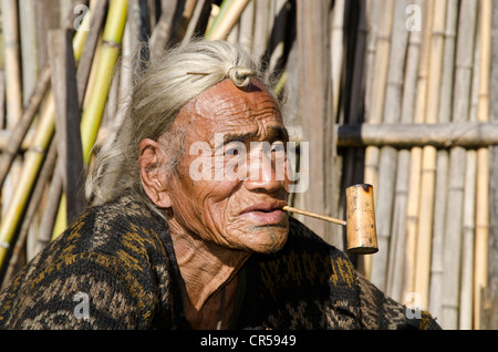 Vieux Apatani homme avec le noeud de cheveux typique au front, en face de sa maison, Hong village, de l'Arunachal Pradesh, Inde, Asie Banque D'Images