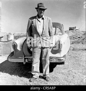 L'Afrique du Sud, années 50. Propriétaire de la mine locale Afrikaaner repose sur sa voiture. Banque D'Images