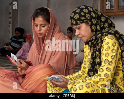 Deux textes de Sikh mesdames réciter les saintes écritures, Amritsar, Punjab, en Inde, en Asie Banque D'Images