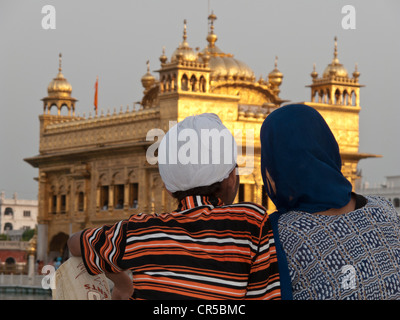 Pèlerins sikhs se reposant devant le Temple d'or après un long voyage à Amritsar, Punjab, en Inde, en Asie Banque D'Images