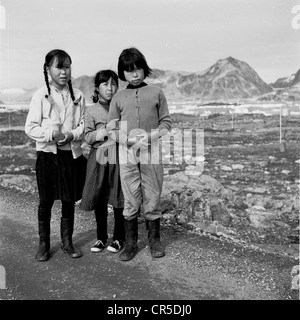 Années 1950. Image historique de trois jeunes Inuits ou Eskimo girls standing ensemble sur un sentier pierreux au Groenland. Banque D'Images