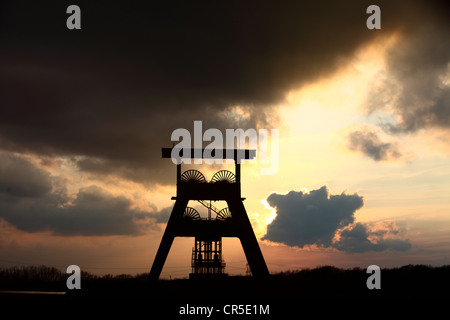 Châtelet d'une ancienne mine de charbon, coucher de soleil, ciel sombre, les nuages. Symbole de la fin de l'exploitation du charbon dans la région de la Ruhr, en Allemagne. Banque D'Images
