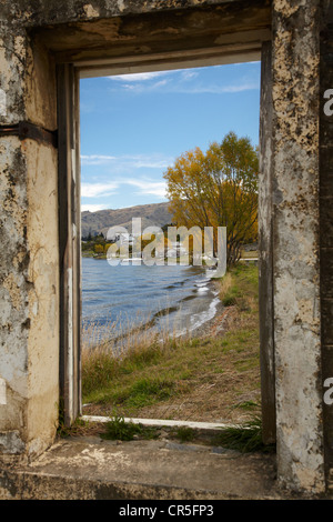 À la recherche d'une fenêtre du bâtiment abandonné à Lake Dunstan et vieille ville de Cromwell, Cromwell, Central Otago, Nouvelle-Zélande Banque D'Images